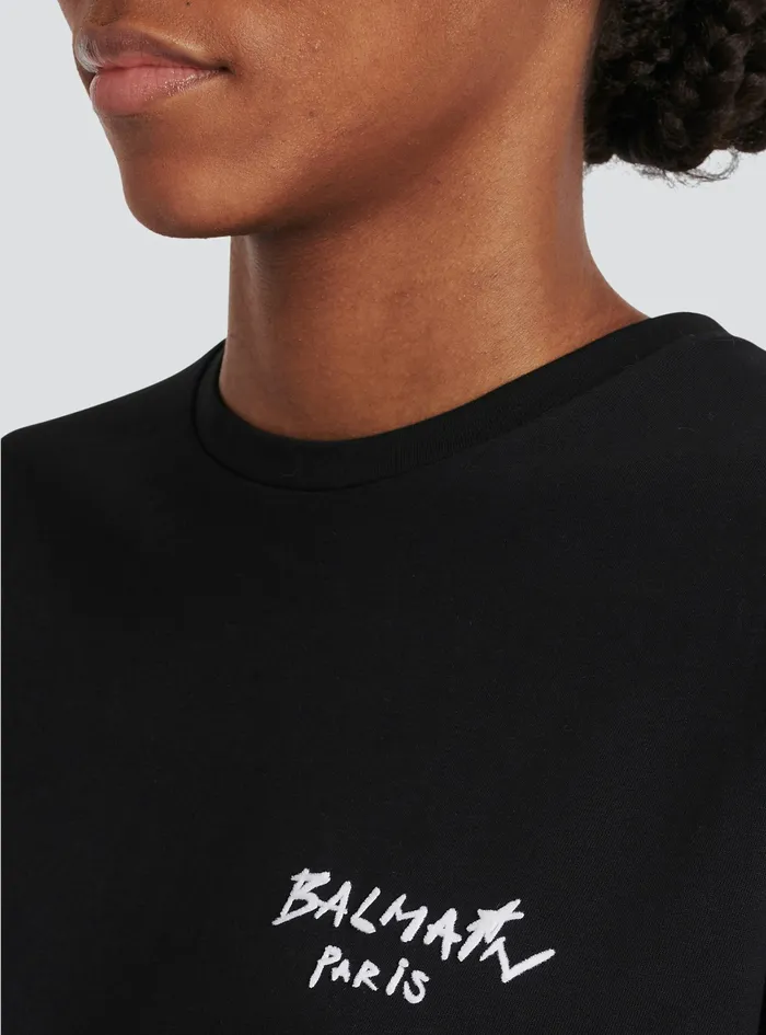Balmain TShirts Womens Cropped Cotton TShirt With Small Flocked Graffiti Balmain Logo Black Balmain TShirts Womens Cropped Cotton TShirt With Small Flocked Graffiti Balmain Logo Black
