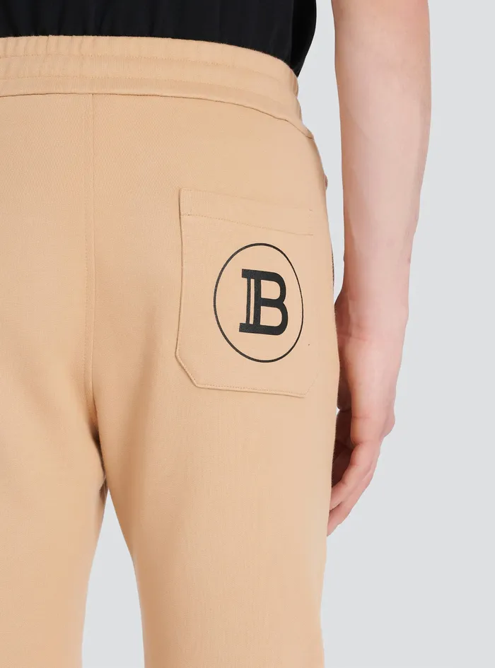 Balmain Trousers And Shorts Mens EcoDesigned Cotton Sweatpants With Black Balmain Logo Print Beige Balmain Trousers And Shorts Mens EcoDesigned Cotton Sweatpants With Black Balmain Logo Print Beige